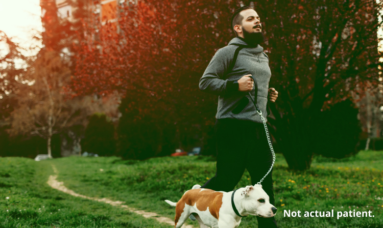 A man jogging with a dog at a park